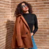 a woman standing in front of a brick wall